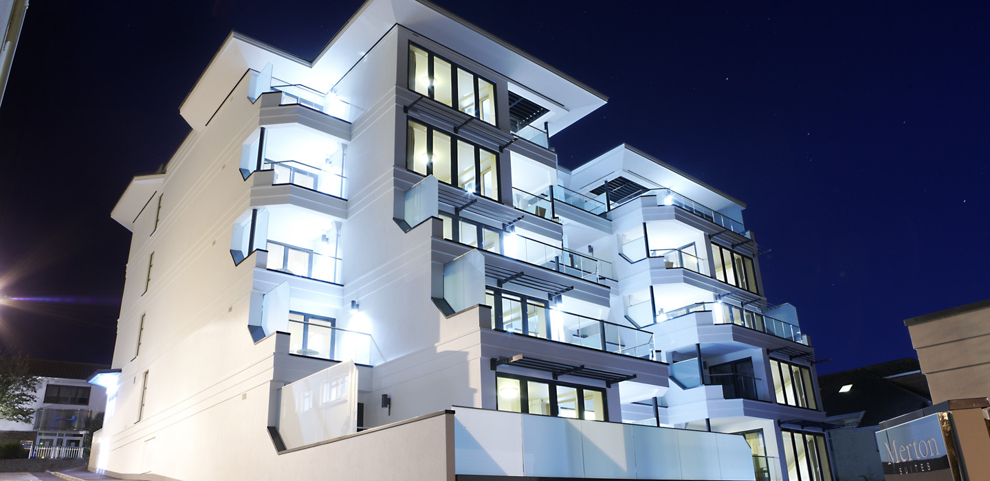 External view of the Merton Suites building, lit up at night